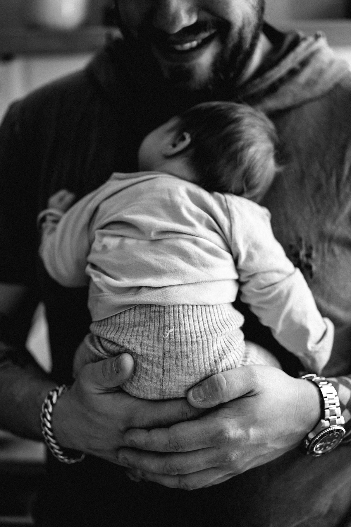 Neugeborenes im Wochenbett, sicher gehalten in erwachsenen Händen, Schwarzweißaufnahme
