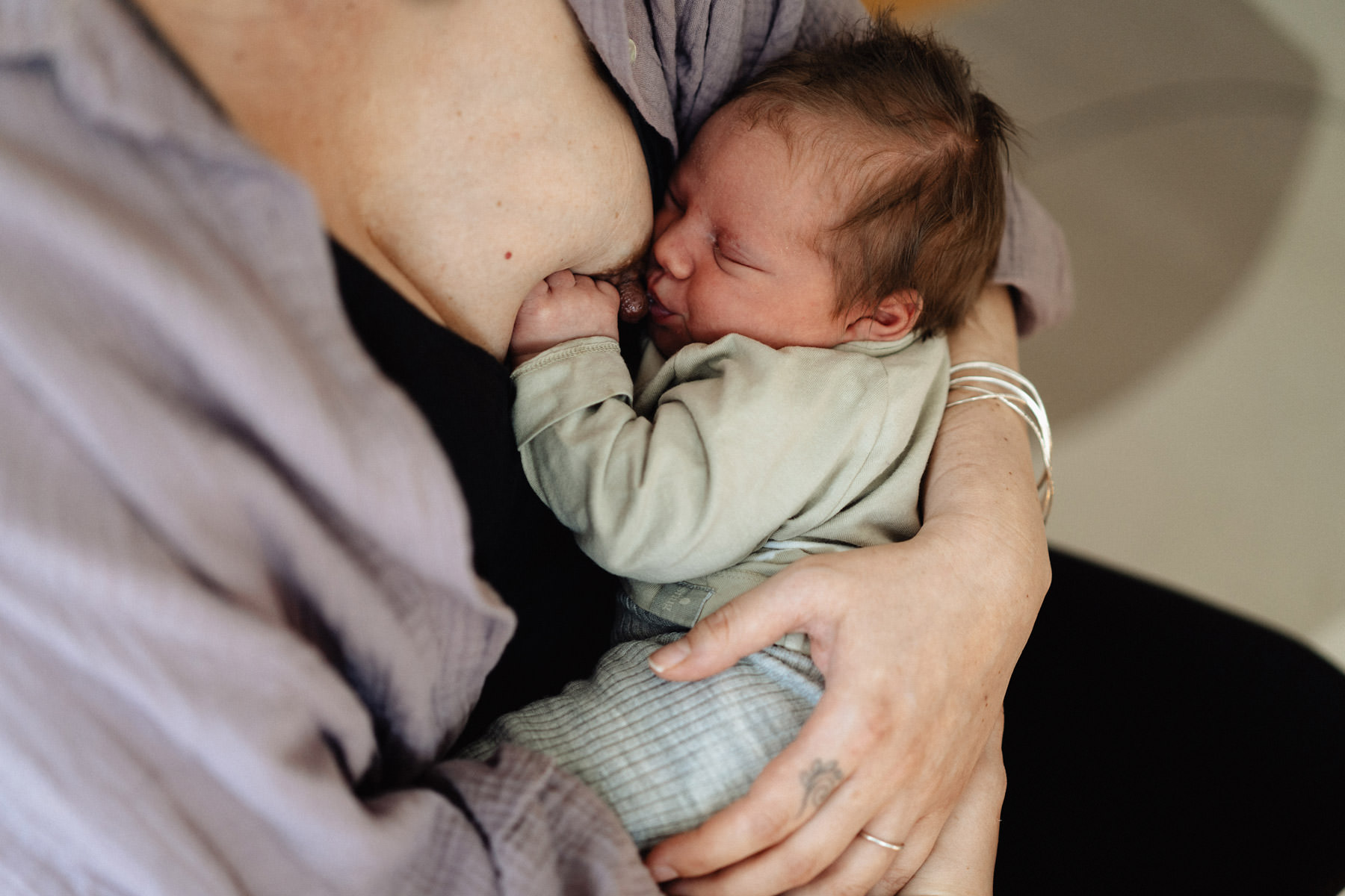 Detailaufnahme eines Neugeborenen beim Stillen – Nähe und Geborgenheit in der Wochenbettzeit.