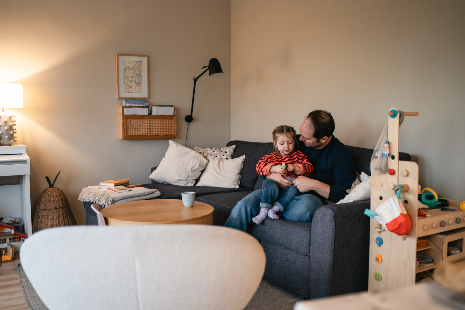 Kind sitzt mir Vater auf dem Sofa