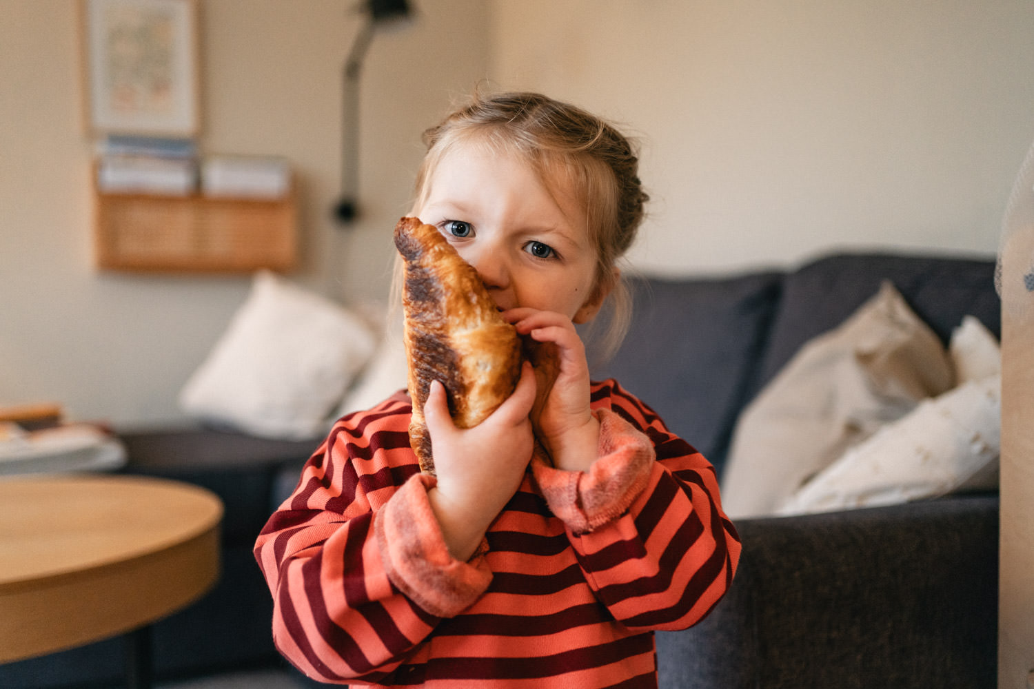 Kind beißt in ein Croissant