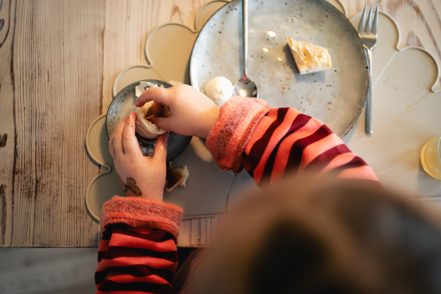 Kind dippt Brot in Frühstücksei