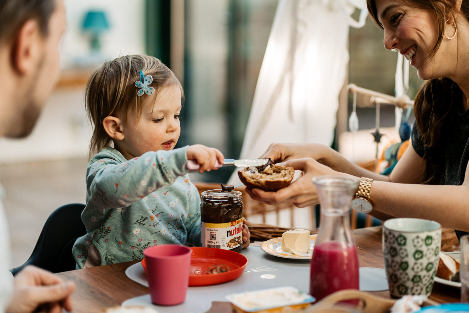 Kind schmiert Mutter  Nutella aufs Brot